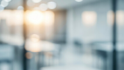 Blurred office interior with glass walls and bright background light, emphasizing a professional workspace with open design and contemporary atmosphere.