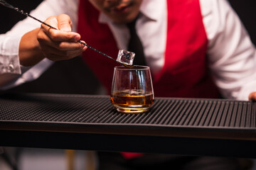 Bartender is pouring whiskey into a glass in a restaurant	