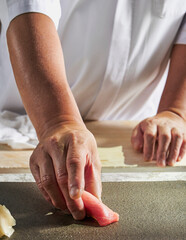 Sushi Chef Serving Maguro Nigiri on Stone Plate