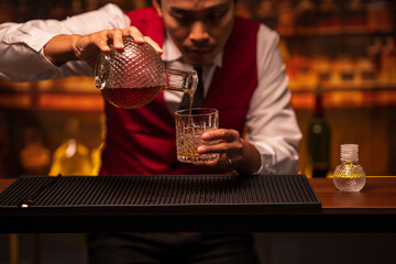 Bartender is pouring whiskey into a glass in a restaurant	