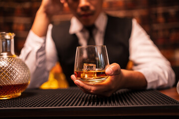Bartender is pouring whiskey into a glass in a restaurant	