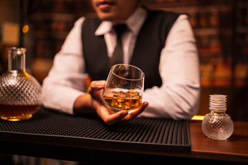 Bartender is pouring whiskey into a glass in a restaurant	