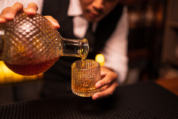 Bartender is pouring whiskey into a glass in a restaurant	