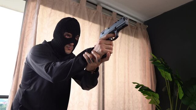 Thief breaking into a house with a gun during the day