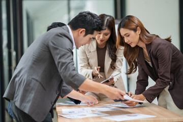 Group of businesspeople are standing in a meeting, exchanging knowledge in the office.
