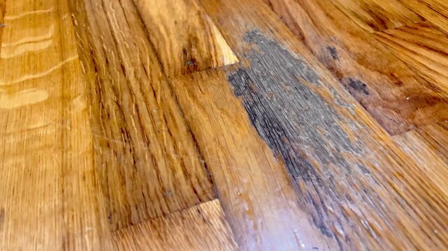 A wooden floor with a dark brown color. The floor is made of wood and has a natural grain pattern