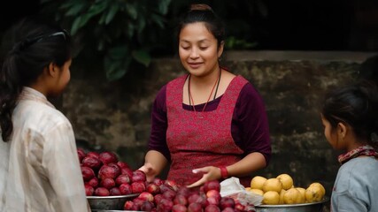 A cheerful fruit seller engaging with young customers at a bustling market, highlighting the vibrant exchange of goods and smiles that reflect the warmth of community commerce.