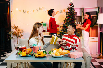Holiday spirit with Asian friends exchanging gifts, sharing laughs, and enjoying a festive Christmas dinner