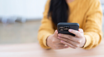 Close-up of a person's hands holding a black smartphone, focused on communication or browsing.