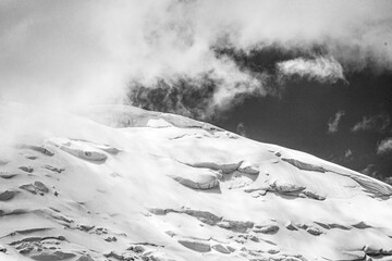 A close-up of a mountain peak in bad weather, leading to the death of climbers in windy weather, snow-capped peaks in the clouds