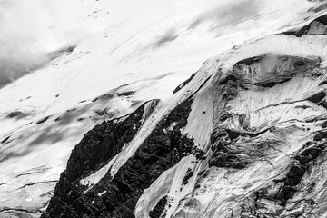 A close-up of a mountain peak in bad weather, leading to the death of climbers in windy weather, snow-capped peaks in the clouds