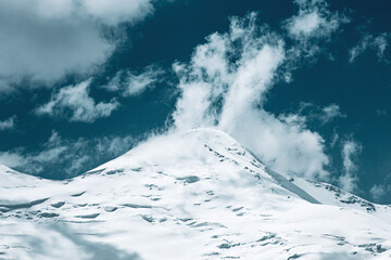 A close-up of a mountain peak in bad weather, leading to the death of climbers in windy weather, snow-capped peaks in the clouds