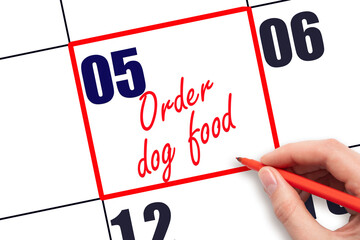 5 th day of the month.  Hand writing Order dog food reminder and drawing red frame on calendar with...