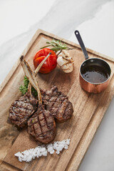 Grilled Lamb Rib Chops Steak with Roasted Vegetables and Gravy Sauce on Wooden Cutting Board