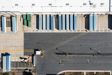 Aerial drone picture of a large warehouse and distribution facility with semi trucks, trailers and loading docks in an industrial area, showing logistics and transportation infrastructure in Hillsboro