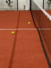 Paddle tennis balls of a red field rubber ground with white lines outdoors, sports concept.