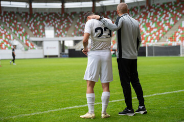 Substitution player and coach next to the field before substitution.