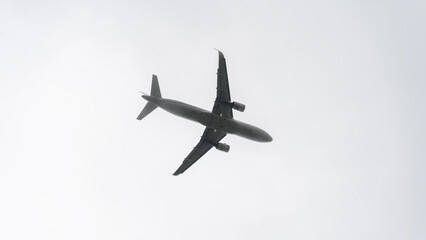 A commercial plane flying through a gray sky filled with fog. The plane is shown close-up, as it takes off and lands, with the fog surrounding it. High quality photo