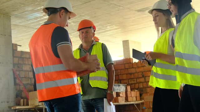 Worker and managers evaluate quality of building materials. Inspectors take into account characteristics of brick to form verification conclusions
