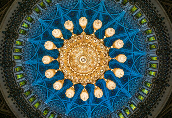 Grand chandelier illuminates ornate blue mosque ceiling