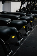 Obraz premium A row of black exercise benches with yellow handles