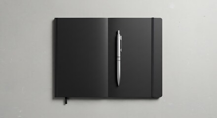 A black notebook and a silver pen are placed on a neutral background for commercial usage and mockups