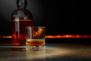 Whiskey with ice on a dark background.