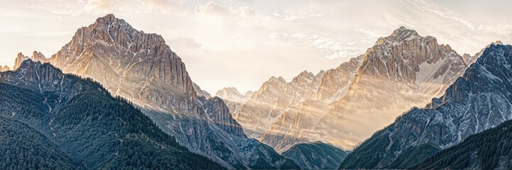 Majestic mountain range at sunrise with golden light illuminating the peaks and valleys in a serene landscape