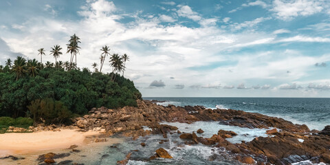 Tropical Rocky Beach With Palm Trees And Ocean Waves Under Blue Sky © Buyanskyy Production