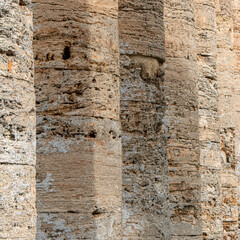 Ancient stone columns show weathered texture and holes
