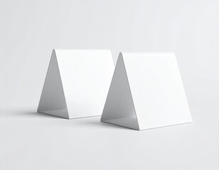 Two blank white triangular table tents on a white background