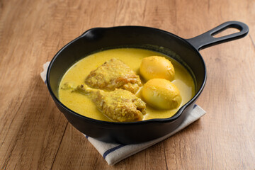 Opor Ayam and egg boiled, Indonesian traditional food served in white bowl, made from chicken cooked with coconut milk and spices. Its served to celebrate Eid Adha and Eid Fitr.