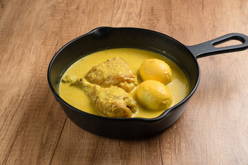 Opor Ayam and egg boiled, Indonesian traditional food served in white bowl, made from chicken cooked with coconut milk and spices. Its served to celebrate Eid Adha and Eid Fitr.