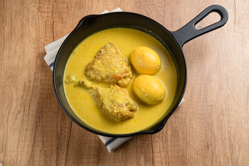Opor Ayam and egg boiled, Indonesian traditional food served in white bowl, made from chicken cooked with coconut milk and spices. Its served to celebrate Eid Adha and Eid Fitr.