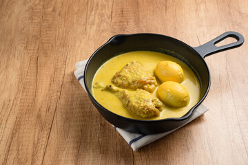 Opor Ayam and egg boiled, Indonesian traditional food served in white bowl, made from chicken cooked with coconut milk and spices. Its served to celebrate Eid Adha and Eid Fitr.