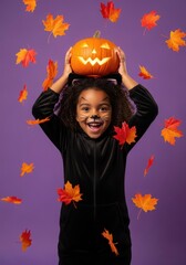  Happy Halloween. Happy black girl in cat costume holding pumpkin above head, purple background, autumn leaves falling.
