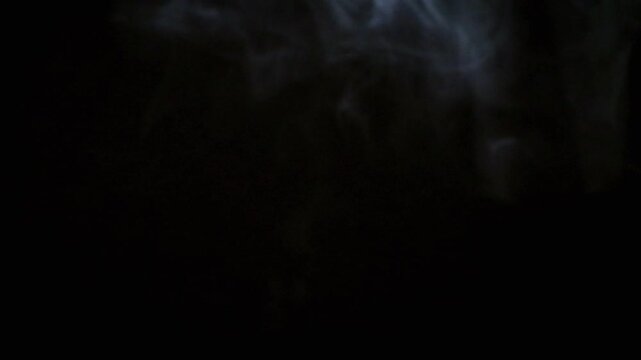Steam from cooking rising upwards. Dark black background. 4K footage
