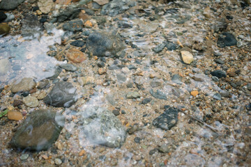 Clear shallow river with visible rocks and sand underwater
