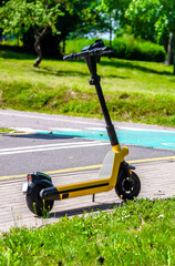 Fototapeta premium Yellow electric scooter are parked on a city Park 
