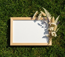 Empty picture frame mockup with flowers and minimal background, perfect for artwork, print, or photography presentation