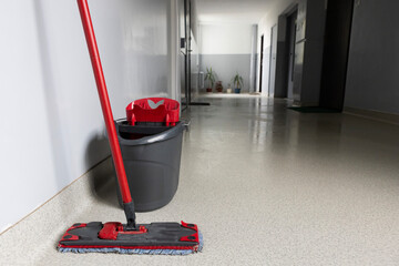 Cleaning supplies ready for use in a corridor of a modern building during daylight hours