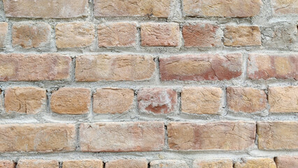 Close up shot of a brick wall with varying shades of red and yellow bricks