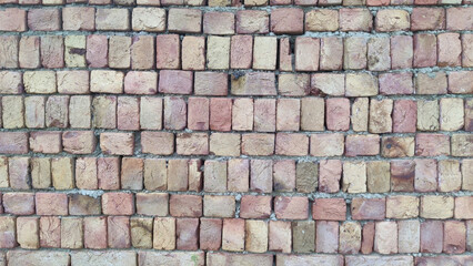 Close up view of a brick wall with light brown and tan colored bricks