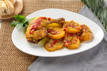 Roasted chicken leg served with potatoes and bell pepper