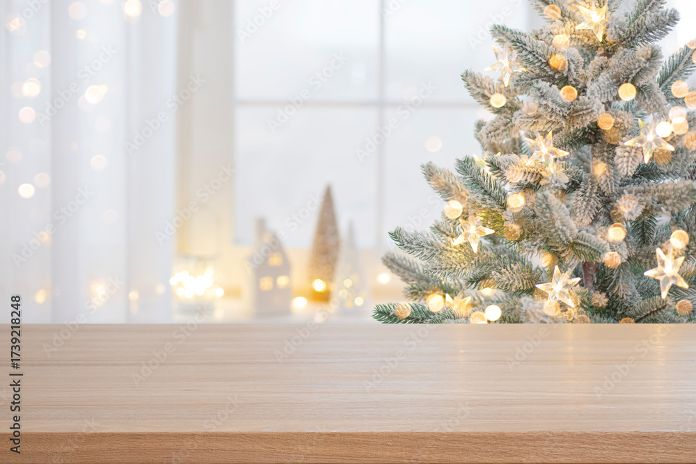 Wall mural christmas presentation empty wooden table top with blurred fir tree and illumination lights backgrou