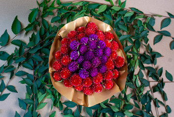 Colorful bouquet of red and purple flowers on green leaf background