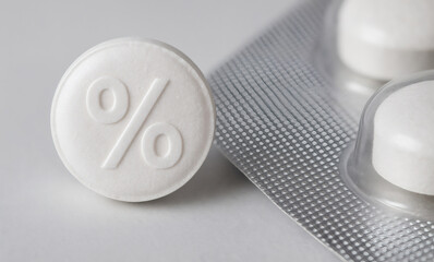 Macro photograph of white pill with embossed percentage symbol beside blister pack representing pharmaceutical discounts and healthcare savings. Symbolizes medication cost reduction.