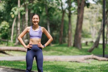 Young woman smiling, standing in park, active lifestyle