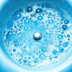 Close-up blue water swirling with bubbles, central droplet