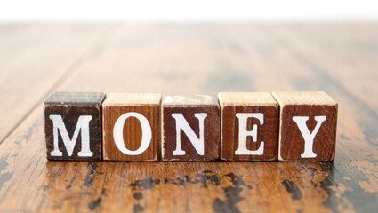 Wooden Blocks Spelling Money on a Rustic Wooden Table Surface